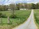 Gravel driveway leads to a single story home with green roof at 13079 Philadelphia Church Rd, Oakboro, NC 28129