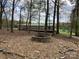 Home exterior with a stone fire pit and surrounding woods at 13079 Philadelphia Church Rd, Oakboro, NC 28129