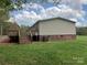 Back of home featuring a wooden deck, brick foundation and lush green lawn at 13079 Philadelphia Church Rd, Oakboro, NC 28129