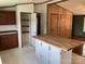 Open kitchen featuring butcher block island, wood cabinets and access to pantry storage at 13079 Philadelphia Church Rd, Oakboro, NC 28129