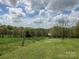 Picturesque landscape featuring lush green fields, mature trees, and a charming fence, offering a peaceful rural setting at 13079 Philadelphia Church Rd, Oakboro, NC 28129