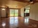 Living room with hardwood floors, wood paneled ceiling, bright windows and a doorway to the kitchen at 13079 Philadelphia Church Rd, Oakboro, NC 28129