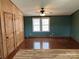 Spacious living area featuring wood floors, a ceiling fan, and built-in wood storage at 13079 Philadelphia Church Rd, Oakboro, NC 28129
