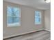 Well lit bedroom with neutral walls, updated flooring, and natural light from two side windows at 132 Riverview Acres Ln, Taylorsville, NC 28681