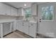 Close up of the bright kitchen with stainless steel dishwasher, sink, and marble countertop at 132 Riverview Acres Ln, Taylorsville, NC 28681