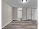 Spacious living room with gray floors, neutral walls, and access to bathroom and multiple doors at 132 Riverview Acres Ln, Taylorsville, NC 28681