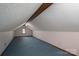 A large attic space with blue carpeting and a window for natural light, perfect for storage at 1478 Smith Farm Rd, Lincolnton, NC 28092