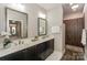 Bathroom with dual sinks, granite counters, decorative mirrors, and walk-in shower with upgraded tile work at 14917 Dewpoint Pl, Huntersville, NC 28078