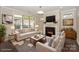 Inviting living room with a cozy fireplace, large windows, and stylish furnishings at 14917 Dewpoint Pl, Huntersville, NC 28078