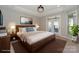 Main bedroom features a tray ceiling, elegant light fixture, and access to private outdoor space at 14917 Dewpoint Pl, Huntersville, NC 28078