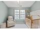 Bright and cozy Bedroom with a crib, a glider chair, and natural light at 1518 Sylvia Ct, Charlotte, NC 28205