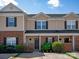 Charming brick and vinyl townhome with manicured landscaping and black window shutters at 1518 Sylvia Ct, Charlotte, NC 28205