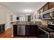 Kitchen with stainless steel dishwasher and view of the living room through the divider at 1518 Sylvia Ct, Charlotte, NC 28205