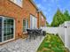 Charming backyard features a stone patio with seating, a manicured lawn, and a privacy fence at 15643 Canmore St, Charlotte, NC 28277
