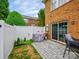 The backyard features a stone patio with a grill, a manicured lawn, and a privacy fence at 15643 Canmore St, Charlotte, NC 28277