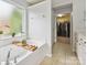 Bright bathroom with soaking tub, white cabinets, and a view into a walk-in closet at 15643 Canmore St, Charlotte, NC 28277