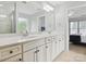 Primary bathroom with double sink vanity, white cabinets and a large mirror at 15643 Canmore St, Charlotte, NC 28277