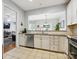 Bright kitchen with stainless appliances, light counter tops, and view into the living room at 15643 Canmore St, Charlotte, NC 28277