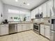 Well-lit kitchen featuring stainless steel appliances, light granite countertops, and cream colored cabinets at 15643 Canmore St, Charlotte, NC 28277
