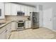 Kitchen with stainless appliances, white cabinets, light counter tops and tile flooring at 15643 Canmore St, Charlotte, NC 28277