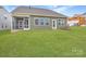 View of the backyard and screened in porch of home with level lawn and green siding at 1996 Copper Path Dr, Fort Mill, SC 29715