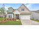 Charming two-story home with a manicured lawn, stone accents, and a two-car garage, creating an inviting curb appeal at 1996 Copper Path Dr, Fort Mill, SC 29715