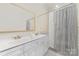Bathroom with double sink vanity, white cabinets, and a shower/tub combination at 20015 N Cove Rd, Cornelius, NC 28031