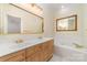 Bright bathroom with double sinks, granite countertops, large mirror and separate tub at 20015 N Cove Rd, Cornelius, NC 28031