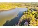 Aerial view of a lakeside property with a grand home surrounded by lush trees and a serene lake at 210 Dexter Ave, Kannapolis, NC 28081