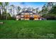 Expansive back exterior showcasing a multi-story home, tiered decks, lush green lawn, and manicured landscaping at 210 Dexter Ave, Kannapolis, NC 28081