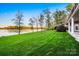 Expansive backyard with green grass, mature trees, and scenic waterfront views at 210 Dexter Ave, Kannapolis, NC 28081
