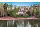 Scenic exterior view of a grand home nestled along the lakefront, featuring a sprawling lawn and mature trees at 210 Dexter Ave, Kannapolis, NC 28081