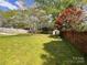 Lush backyard with mature trees, brick wall, privacy fence, and storage shed, offering ample space at 217 Windsor Dr, Shelby, NC 28150