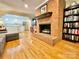 Cozy living room with a brick fireplace and adjacent kitchen with white cabinets and stainless steel appliances at 217 Windsor Dr, Shelby, NC 28150