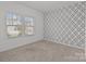 Bedroom featuring geometric wallpaper accent wall, plush carpet, and bright windows offering natural light at 224 Old Harbor Dr, Mount Gilead, NC 27306