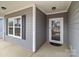 Inviting entryway featuring a glass-paneled front door and sleek gray siding, providing a welcoming first impression at 224 Old Harbor Dr, Mount Gilead, NC 27306