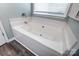 Bathroom showcasing a corner soaking tub with chrome fixtures and a window view at 239 Bradford Glyn Dr, Mooresville, NC 28115