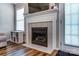 Close-up of the living room fireplace with a white mantle, tile surround, and shelving, plus hardwood flooring at 239 Bradford Glyn Dr, Mooresville, NC 28115