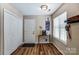 Hallway featuring a coat closet, coffee bar table, giraffe art, and wood flooring at 239 Bradford Glyn Dr, Mooresville, NC 28115