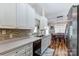 Galley kitchen featuring white cabinets, stainless steel appliances, tile backsplash, and wood flooring at 239 Bradford Glyn Dr, Mooresville, NC 28115