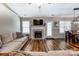 Bright living room with fireplace, wood floors, and neutral walls adjacent to a dining area with seating at 239 Bradford Glyn Dr, Mooresville, NC 28115