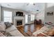 Spacious living room featuring wood flooring, a fireplace, and seamless flow to the adjacent dining area at 239 Bradford Glyn Dr, Mooresville, NC 28115