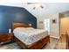Bedroom boasts navy accent wall, ceiling fan, and wood furniture at 239 Bradford Glyn Dr, Mooresville, NC 28115
