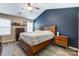 Bedroom boasts navy accent wall, ceiling fan, and wood furniture at 239 Bradford Glyn Dr, Mooresville, NC 28115