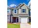 Charming townhome featuring a two-car garage, green siding, and a well-manicured front lawn at 2792 Yeager Nw Dr, Concord, NC 28027