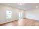 Well-lit living room with hardwood floors, large window, and sliding glass door to a patio at 2792 Yeager Nw Dr, Concord, NC 28027