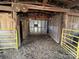 Interior of a barn with a hay-covered floor and yellow metal gates at 291 Love Valley Rd, Statesville, NC 28625