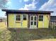 Whimsical, brightly colored shed with repurposed doors and vintage decor in a yard at 291 Love Valley Rd, Statesville, NC 28625