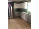 Kitchen featuring stainless steel refrigerator, tile backsplash, grey cabinets, and durable tile flooring at 401 Plymouth St, Kannapolis, NC 28083