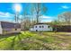 Spacious backyard featuring a well-maintained lawn, a charming house, and a detached garage at 403 Greenbriar S Rd, Statesville, NC 28625